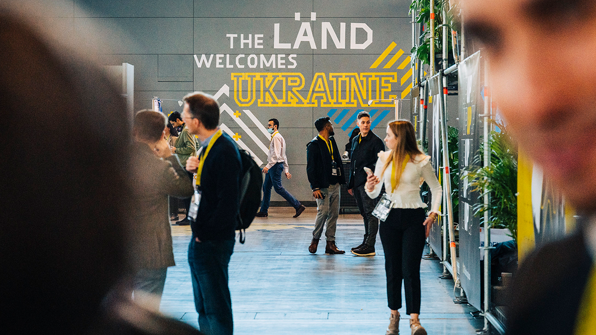 Fotoaufnahme in den Hallen der Landesmesse Stuttgart beim Start-up BW Summit 2022 mit Wandbeschriftung: The Länd welcomes Ukraine.