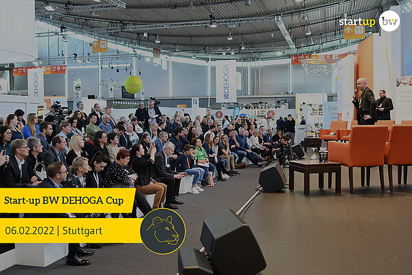 Bühne mit Publikum in einer Messehalle.