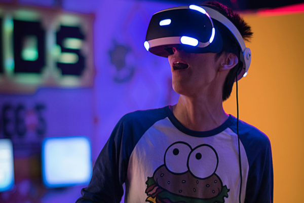 Eine männliche Person nimmt an einem VR-Game teil und trägt eine VR-Brille.