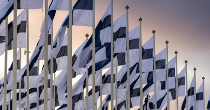 Wehende finnische Flaggen an Fahnenmasten.