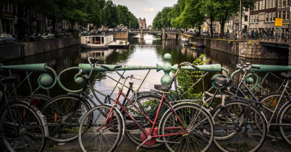 Mehrere Fahrräder an einer Brücke über einem Kanal in Amsterdam.