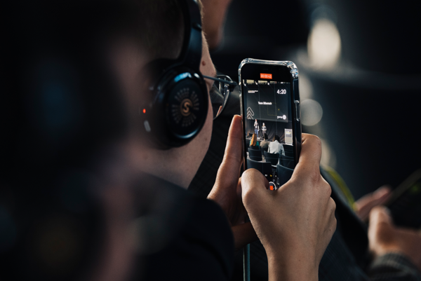 Mann mit Kopfhörer fotografiert mit seinem Smartphone.