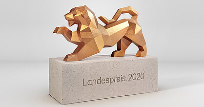 Trophäe für den Landespreis junge Unternehmen 2020. Goldener Löwe auf steinernem Sockel.