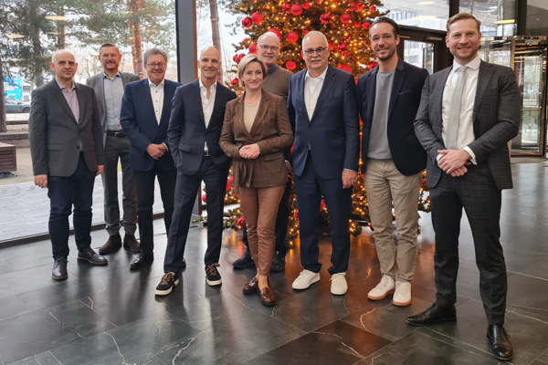Gruppenbild der Mitglieder des Start-up BW Think Tanks mit Wirtschaftsministerin Dr. Nicole Hoffmeister-Kraut vor einem geschmückten Weihnachtsbaum im Foyer der VECTOR Informatik GmbH in Stuttgart.
