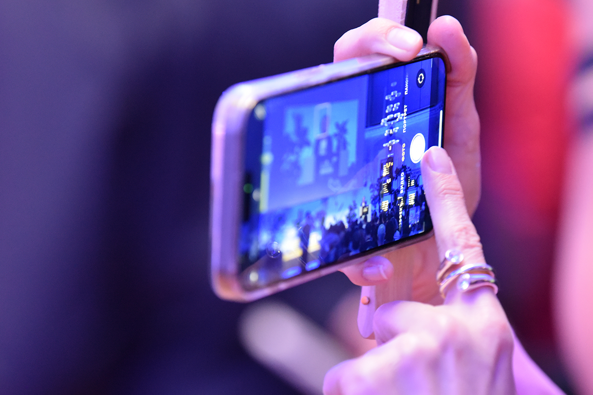 Zwei Hände halten ein Handy. Auf dem Display des Smartphones ist das Bühnenbild des Start-up BW Summits 2025 zu sehen. Bildrechte: Arne Knust.