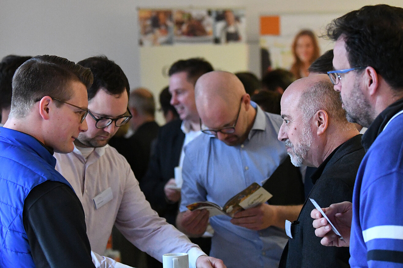 A group of men talking and networking.