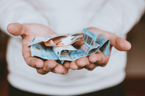 Eine Person hält mehrere Euro-Geldscheine in ihren Handflächen.