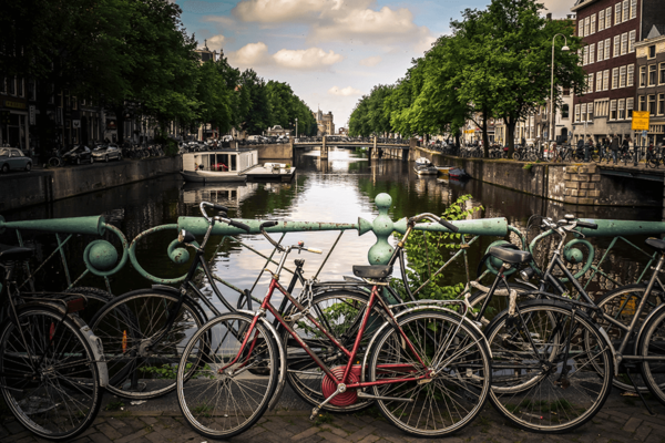 Mehrere Fahrräder an einer Brücke über einem Kanal in Amsterdam.