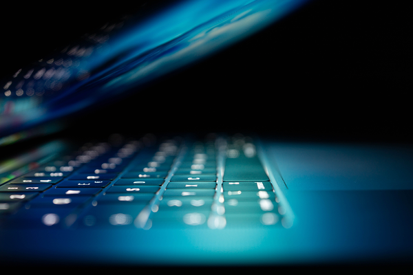 Ein halbgeöffneter Laptop mit einer beleuchteten Tastatur.