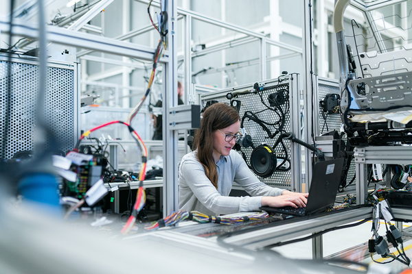 Eine Ingenieurin führt Tests an einer industriellen Maschine durch.