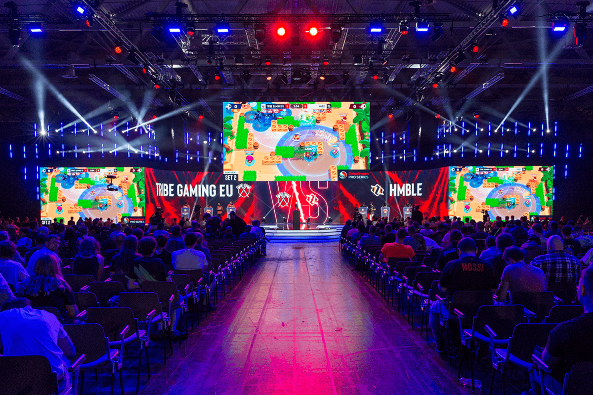 Frontalaufnahme der Center Stage der Messe Gamescom in Köln mit Blick auf den Hauptzugang zur Bühne sowie auf das sitzende Publikum von hinten.