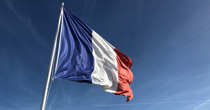 Die Länderflagge von Frankreich an einem Mast über dem blauen Himmel.