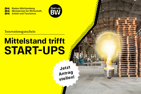 Leuchtende Glühbirne vor einem Palettenstapel in einer Lagerhalle.