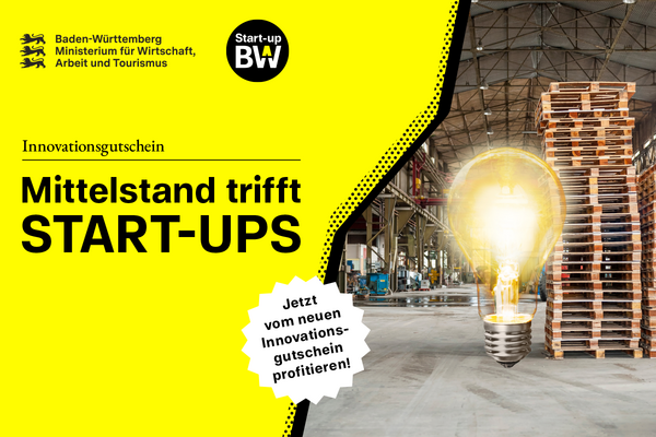 Leuchtende Glühbirne vor einem Palettenstapel in einer Lagerhalle.